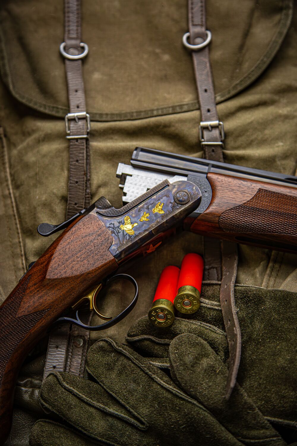 Engraved shotgun with shells and hunting gloves